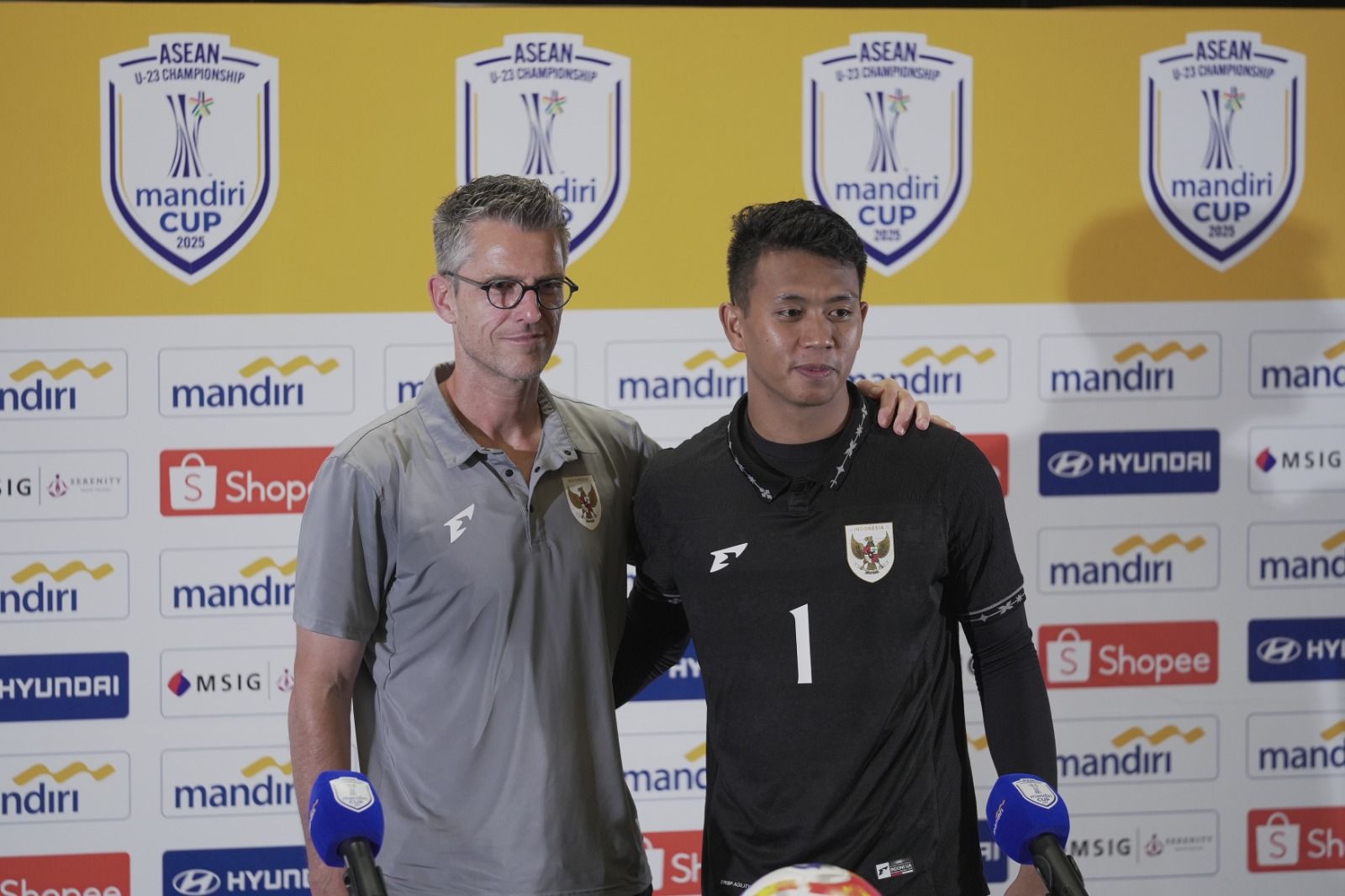 Frank van Kempen sebagai asisten pelatih Timnas U-23 Indonesia (baju abu-abu) bersama Muhammad Ardiansyah pada jumpa pers usai lawan Thailand U-23 di SUGBK, Jakarta, 25 Juli 2025. (Firas Naufal/Skor.id)