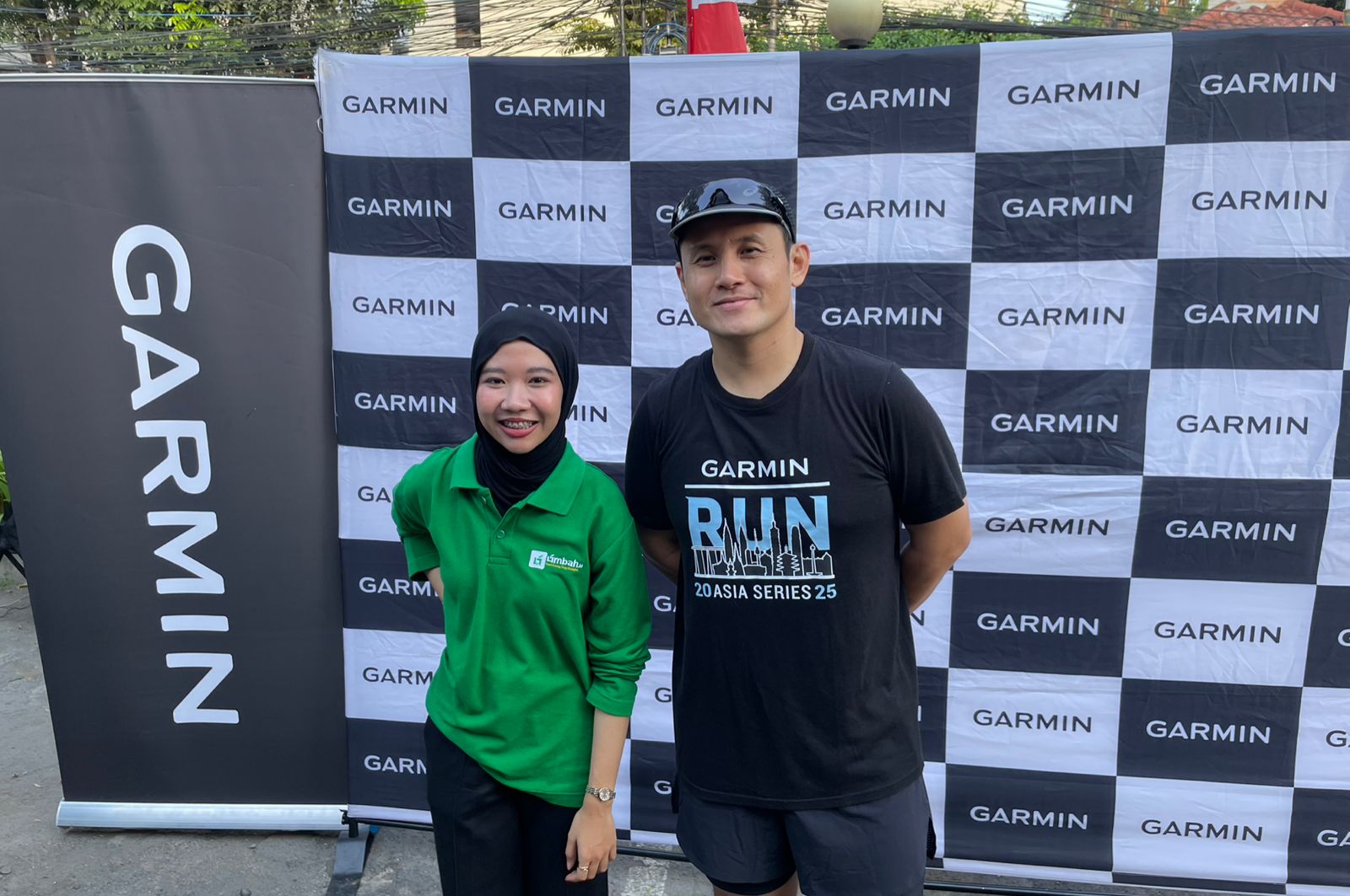 Marketing Communication Manager Garmin Indonesia, Rian Krisna, bersama Marketing & Business Development Limbah.id, Alfiya Sania (hijau), saat Road to Garmin Run: Plogging with Limbah.id di Jakarta, 3 Agustus 2025. (Taufani Rahmanda/Skor.id)