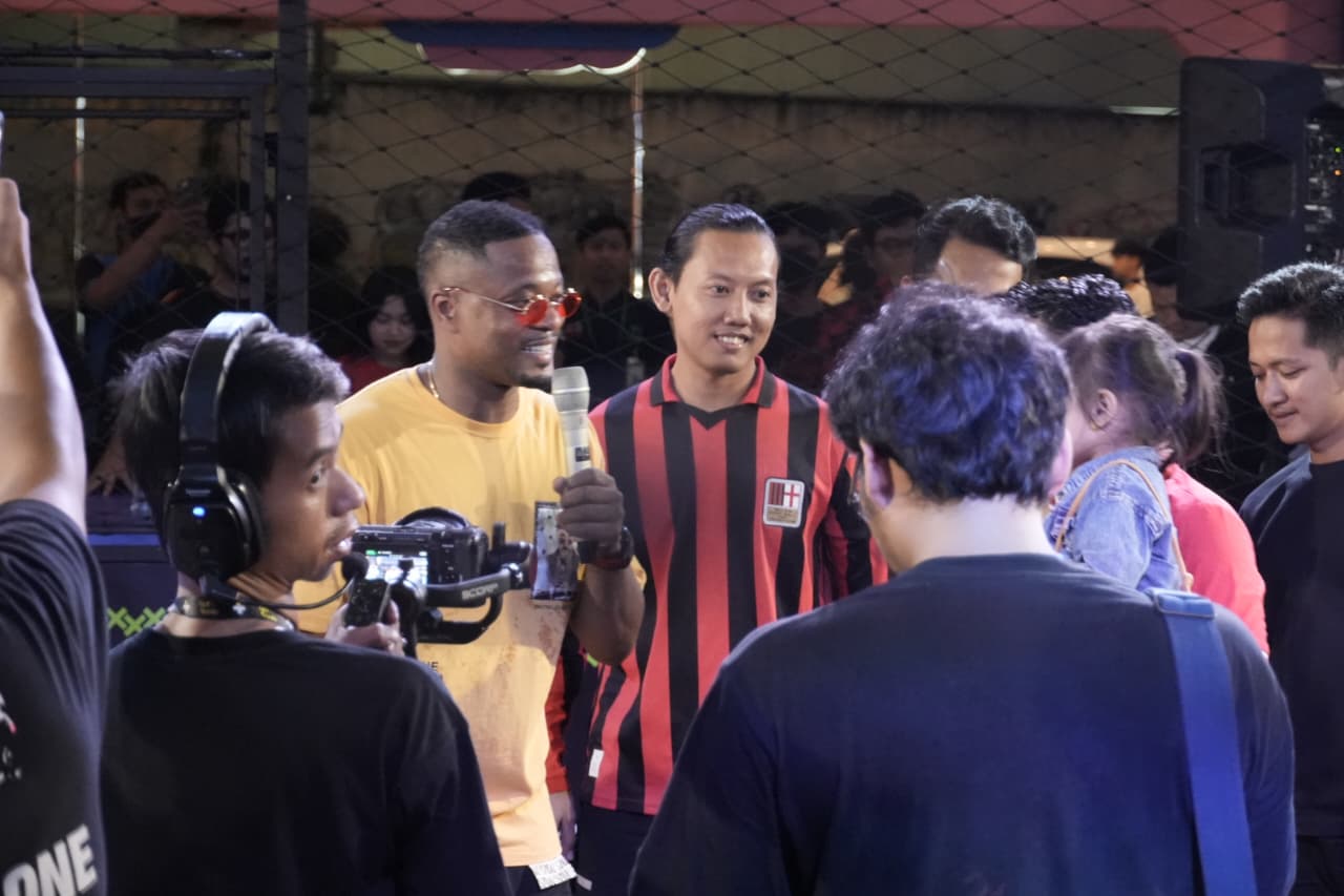Legenda Manchester United dan Timnas Prancis, Patrice Evra (baju kuning), jadi komentator pada Liga Kita Festival di Cilandak Town Square, Jakarta, pada 9 November 2025. (Dok. Offside Corp)