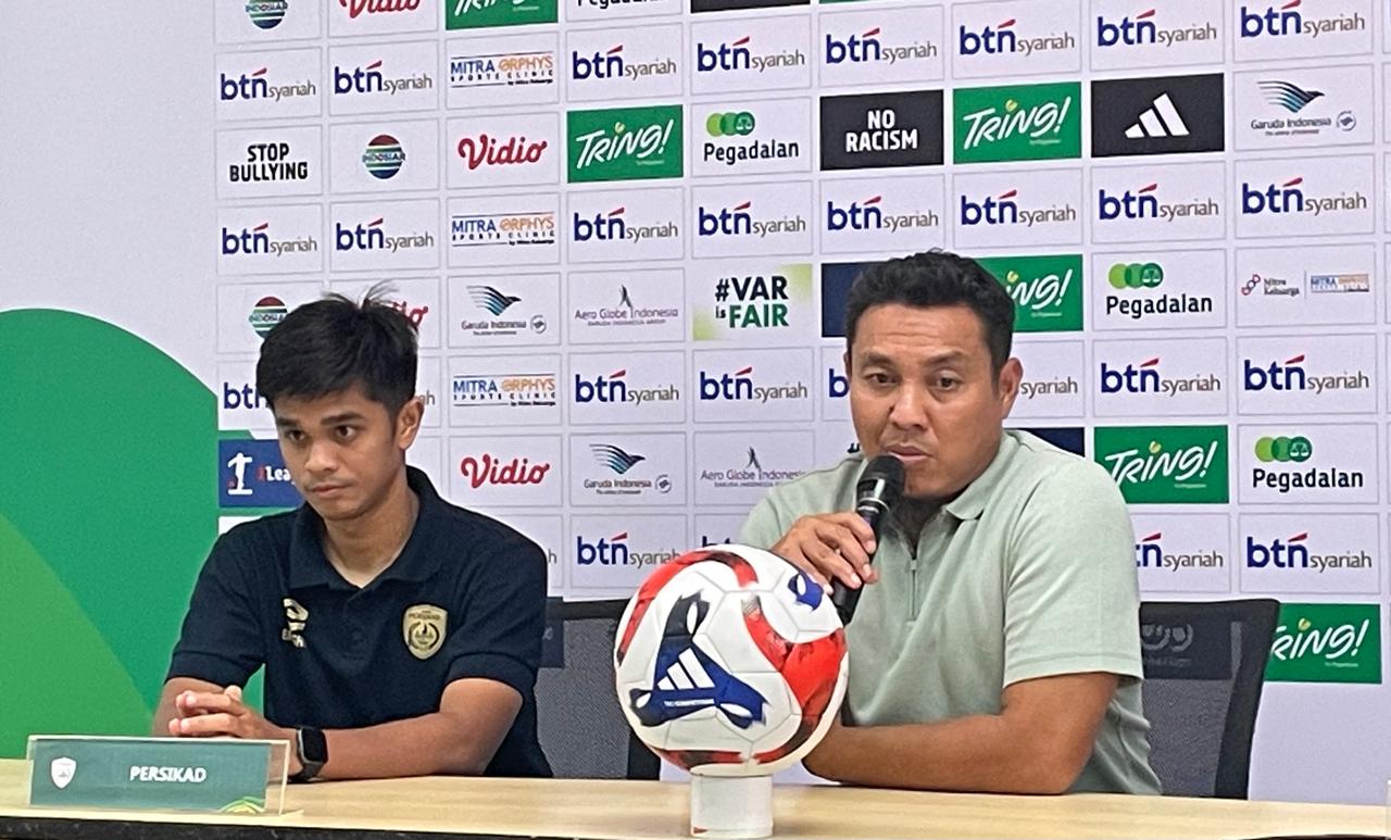 Pelatih Persikad Depok, Achmad Zulkifli (baju hijau), pada jumpa pers usai menjamu Adhyaksa FC di Stadion Pakansari, Bogor, dalam Championship 2025-2026 pada 24 November 2025. (Taufani Rahmanda/Skor.id)